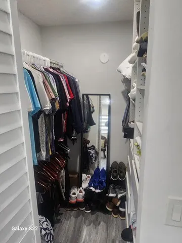 a view of walk in closet with clothes and shoes
