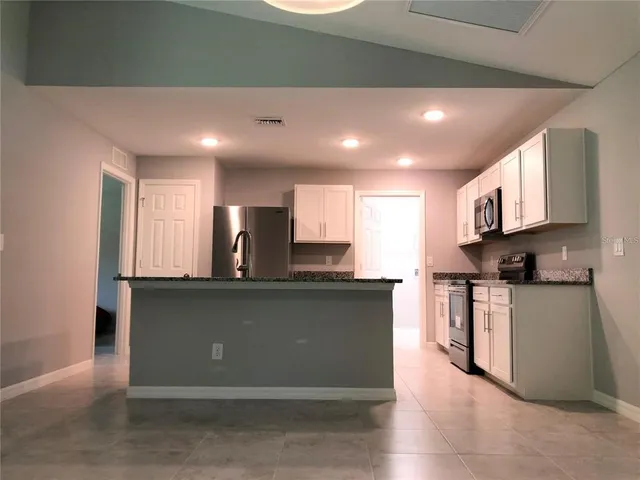 a kitchen with stainless steel appliances granite countertop a refrigerator a stove top oven a sink and dishwasher