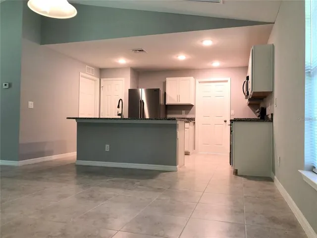 a kitchen with stainless steel appliances granite countertop a refrigerator and a sink