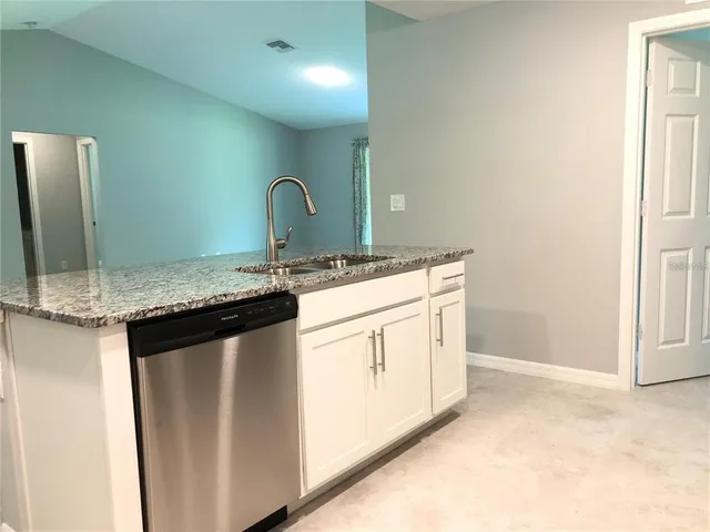 a kitchen with granite countertop a sink and cabinets