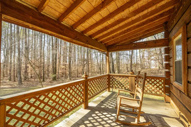 a view of a porch with wooden floor and furniture