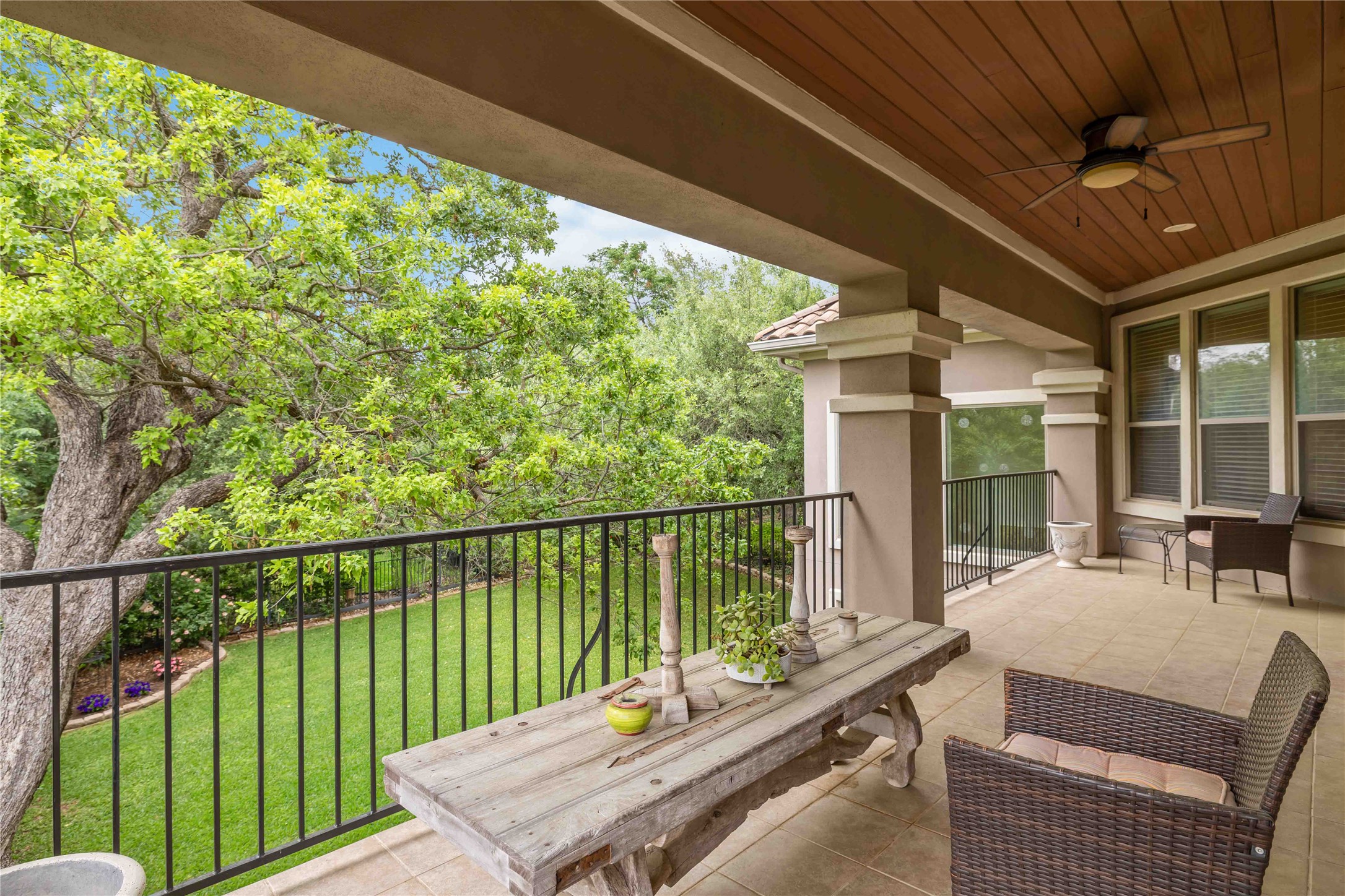15200 Spillman Ranch Loop Austin, TX 78738 - Photo 33 of 40 Covered patio area featuring a ceiling fan, wood plank ceiling, and views of mature trees and a lawn