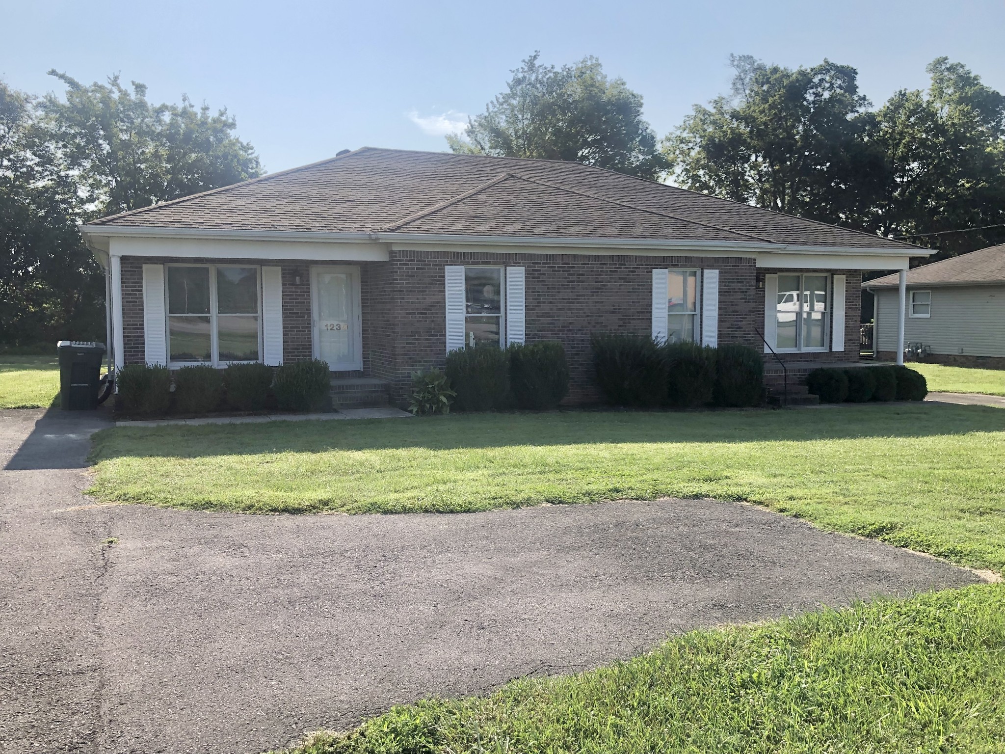 a front view of house with yard and green space