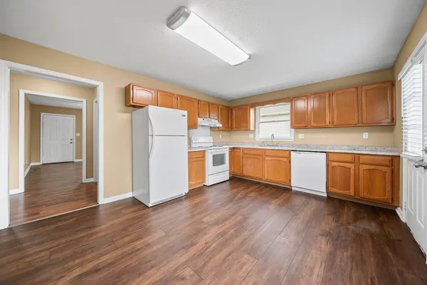 a kitchen with stainless steel appliances a refrigerator and wooden floor