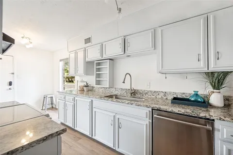 a kitchen with stainless steel appliances granite countertop a sink stove and cabinets
