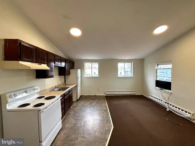 a large kitchen with stainless steel appliances a stove a sink and a microwave