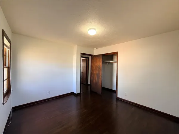 an empty room with wooden floor and closet