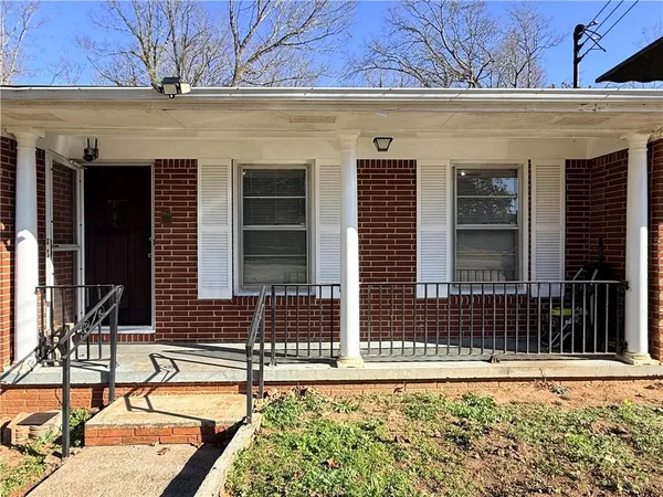 front view of a brick house with potted plants