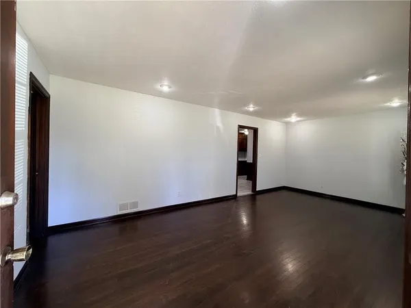 a view of an empty room with wooden floor