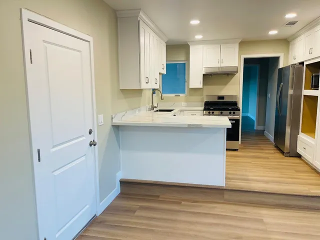 a kitchen with stainless steel appliances granite countertop a white stove top oven and refrigerator