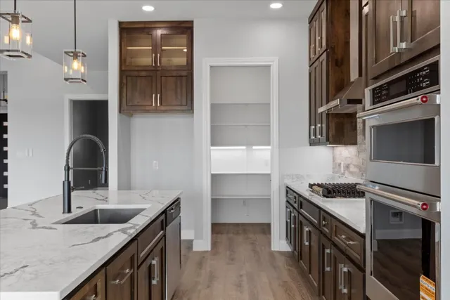 a kitchen with stainless steel appliances granite countertop a sink and a stove