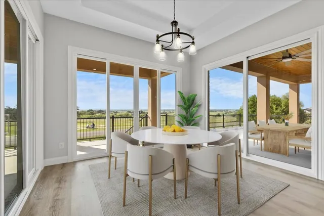 a view of a dining room with furniture large windows and wooden floor