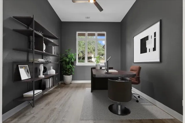 a view of a workspace with furniture and a window