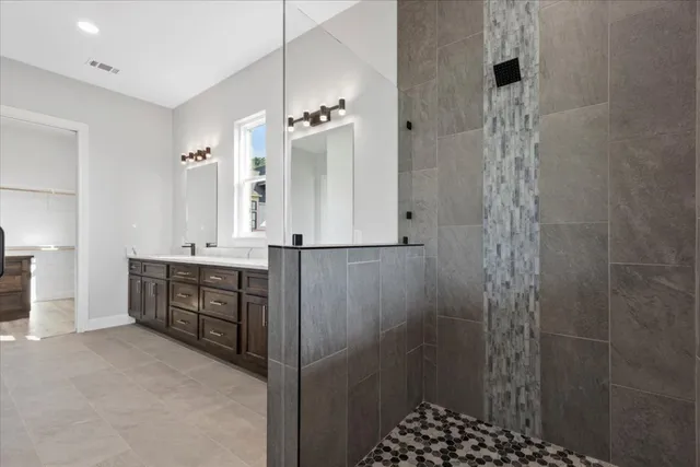 a bathroom with a double vanity sink a toilet and shower