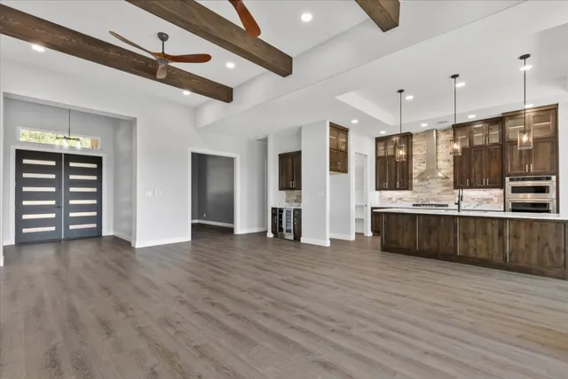 a view of a kitchen with kitchen island a sink stainless steel appliances and cabinets