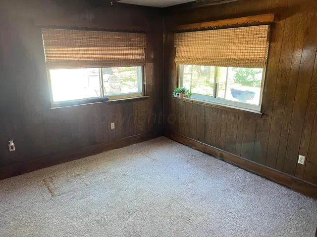 en empty room with windows and ceiling fan