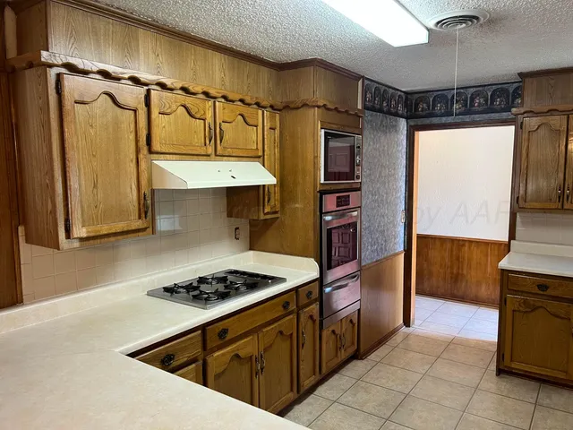 a kitchen with stainless steel appliances granite countertop a refrigerator and a stove