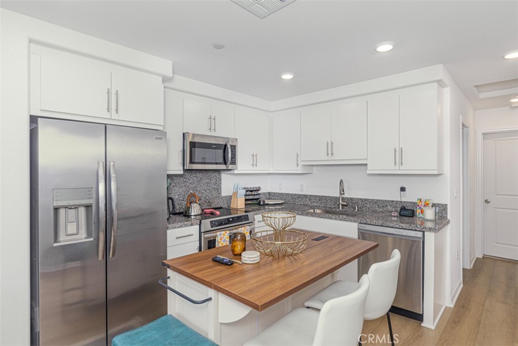 7395 Olive Grv Street Riverside, CA 92507 - Photo 9 of 18 Fully equipped kitchen with granite countertops and stainless steel appliances.
