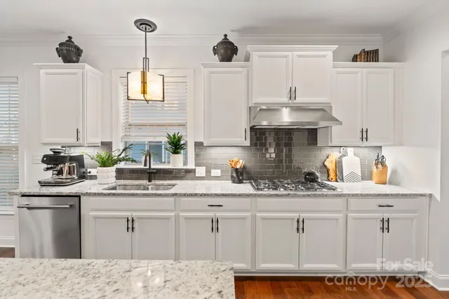 a kitchen with granite countertop a sink stainless steel appliances and cabinets