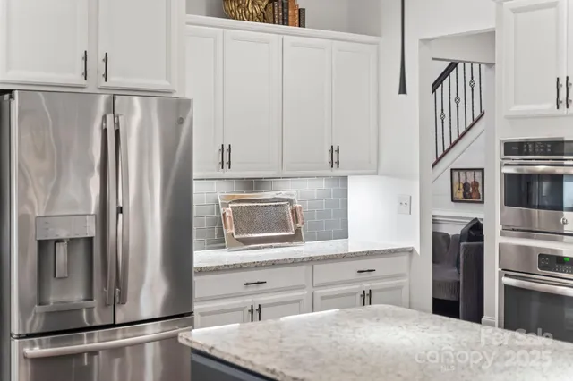 a kitchen with stainless steel appliances a refrigerator sink and cabinets