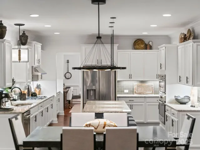 a kitchen with a sink dishwasher a stove and a refrigerator with wooden floor
