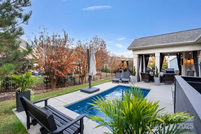a view of a patio with couches table and chairs with potted plants and large tree