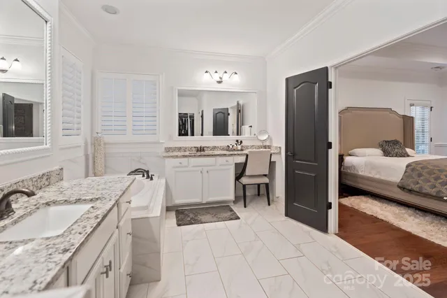 a en suite bathroom with a granite countertop sink and a mirror