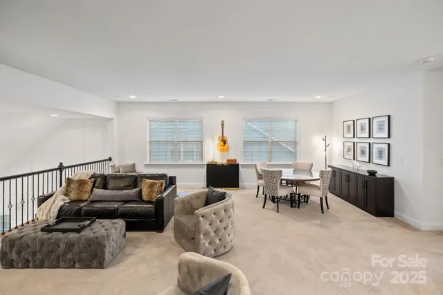 a living room with furniture kitchen view and a window