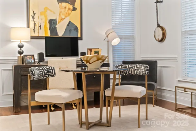 a kitchen with a table chairs and a painting on the wall