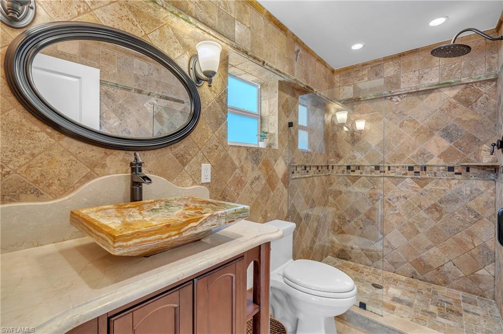 3001 50th Street Southwest Naples, FL 34116 - Photo 17 of 46 a bathroom with a sink a toilet and a mirror