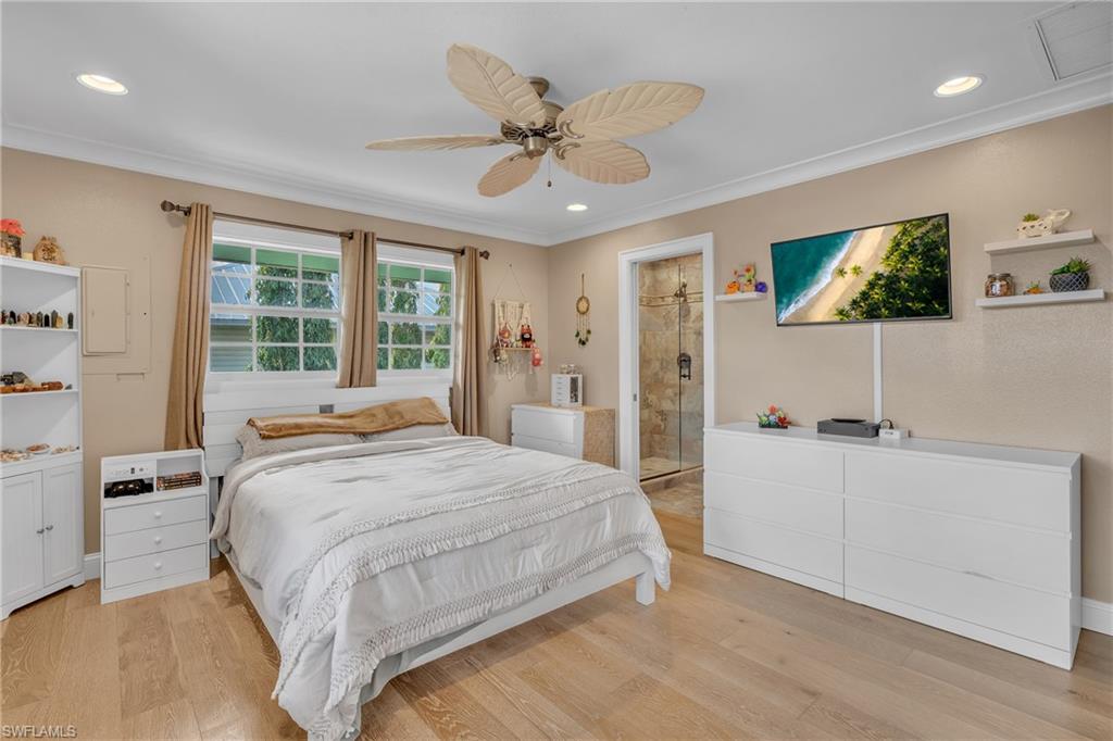 3001 50th Street Southwest Naples, FL 34116 - Photo 19 of 46 a bedroom with a large bed and a chandelier