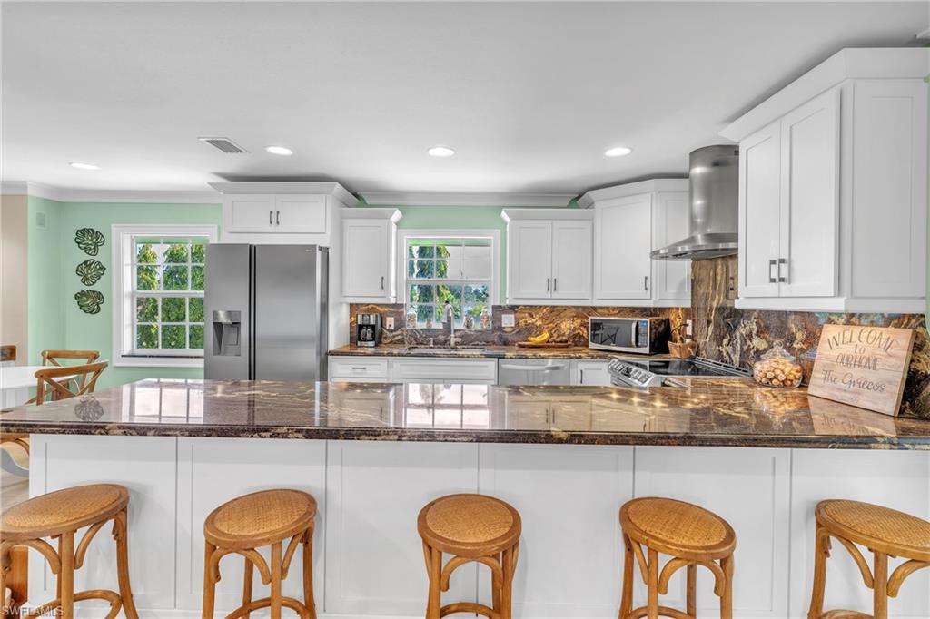3001 50th Street Southwest Naples, FL 34116 - Photo 5 of 46 a kitchen with cabinets a sink stainless steel appliances and windows