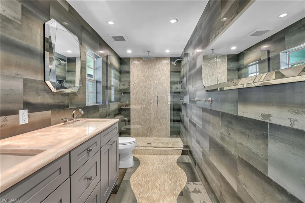 3001 50th Street Southwest Naples, FL 34116 - Photo 7 of 46 a bathroom with a granite countertop sink mirror vanity and toilet
