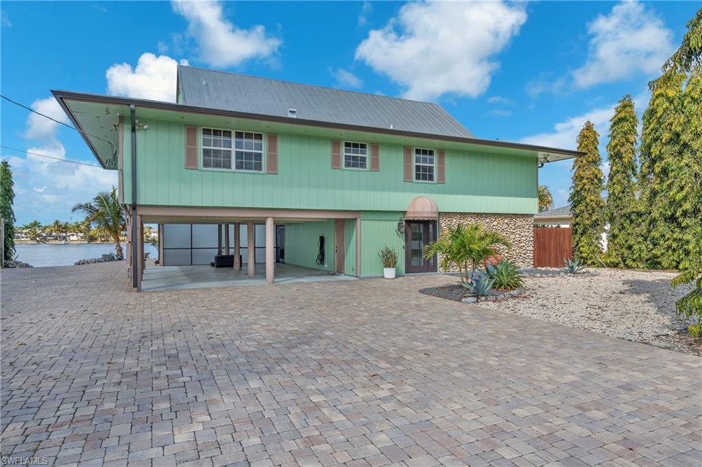 3001 50th Street Southwest Naples, FL 34116 - Photo 9 of 46 a view of a house with a patio and a yard