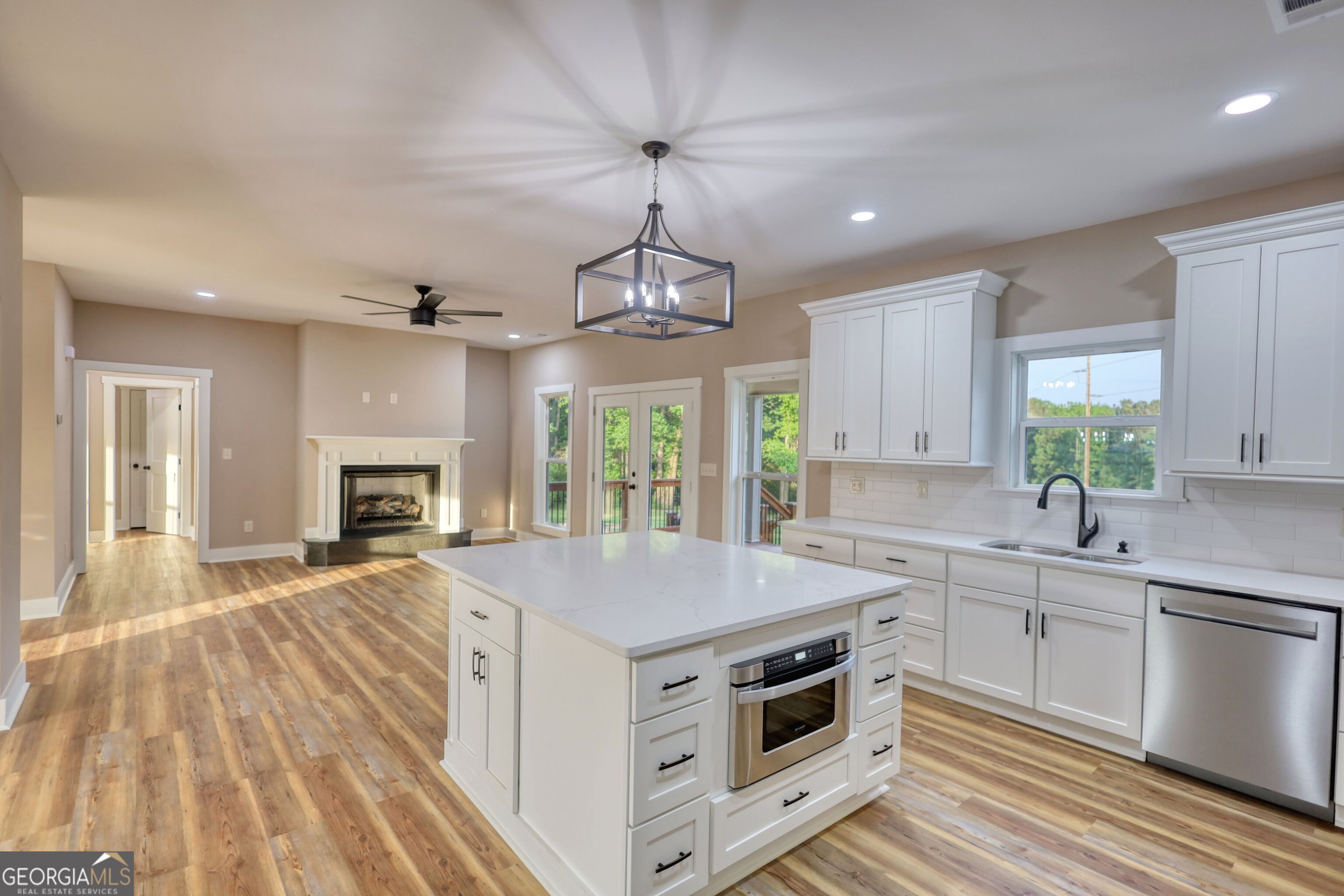 2941 Old Buckhead Road Madison, GA 30650 - Photo 21 of 58 a kitchen with a stove center island a sink cabinets and a wooden floor
