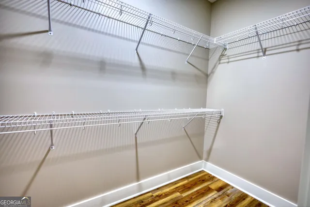 a view of a big room with windows and chandelier fan