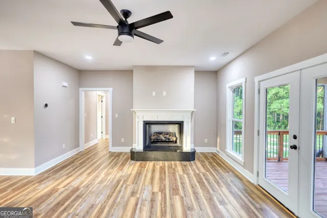 a view of a livingroom with a fireplace wooden floor and window