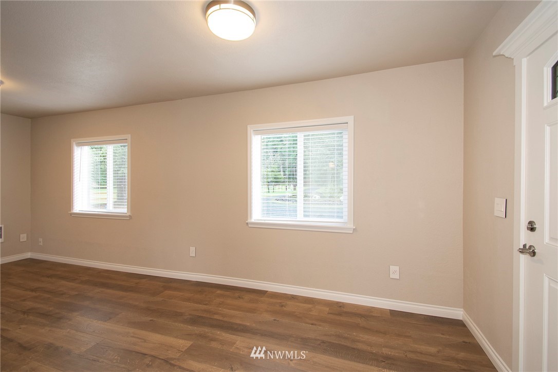 15941 Littlerock Road Southwest Rochester, WA 98579 - Photo 11 of 31 an empty room with wooden floor and windows