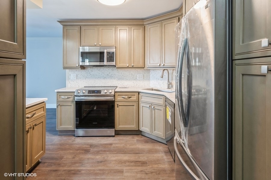 6033 North Sheridan Road, Unit 5D Chicago, IL 60660 - Photo 3 of 11 a kitchen with white cabinets and stainless steel appliances