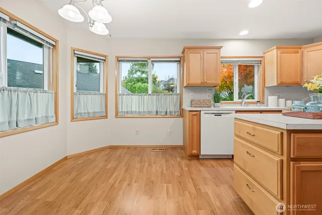 a kitchen with a wooden floor window and cabinets