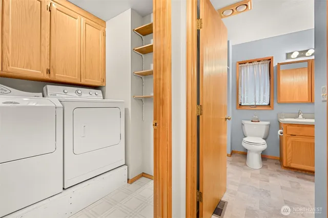 a bathroom with a granite countertop sink and a toilet