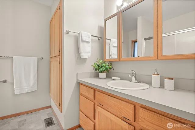 a bathroom with a granite countertop sink and a mirror