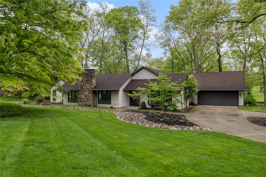 This private retreat offers a beautiful exterior with ample greenery and a welcoming driveway.