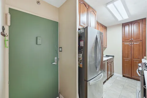 a view of a refrigerator in kitchen and cabinets