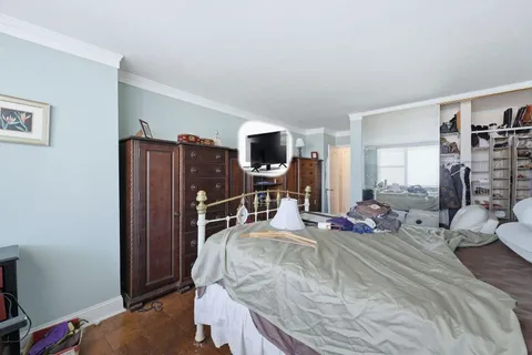 a bedroom with a bed furniture and a flat tv screen