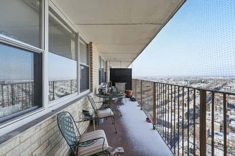 a balcony with chairs and wooden floor