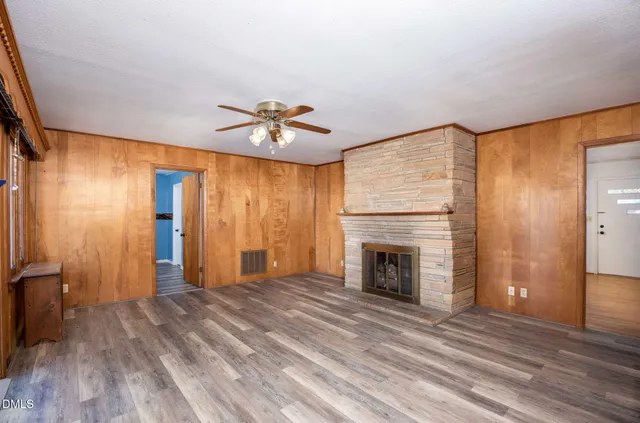 a view of an empty room with a fireplace and a window