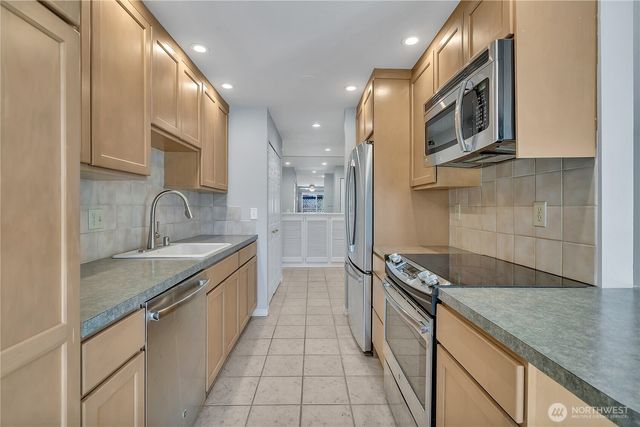 a kitchen with granite countertop stainless steel appliances a sink and cabinets