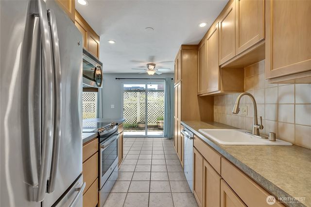 a kitchen with stainless steel appliances granite countertop a sink and a refrigerator