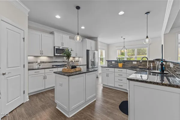 a kitchen with granite countertop a sink stove and refrigerator